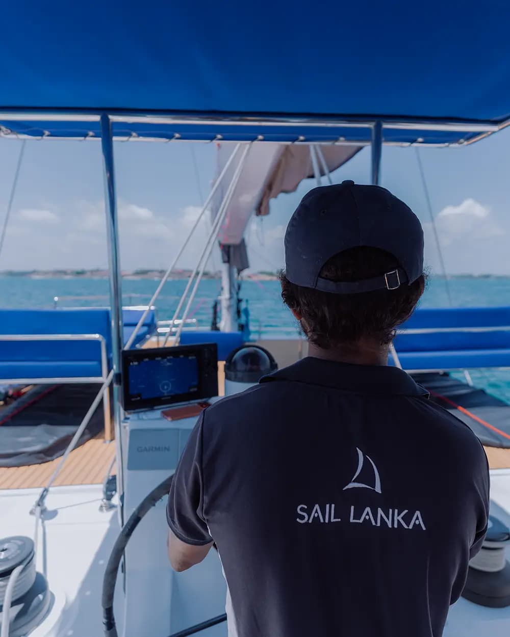 A Sail Lanka skipper at the helm of a catamaran